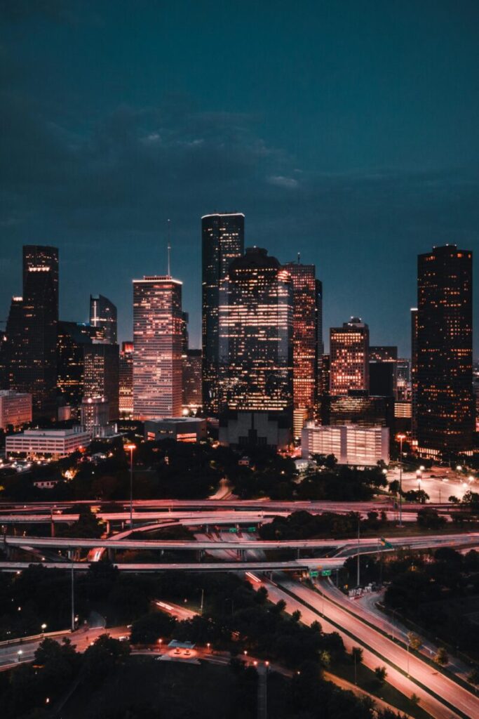 A captivating aerial view of Houston's skyline at night, showcasing modern skyscrapers and illuminated highways.